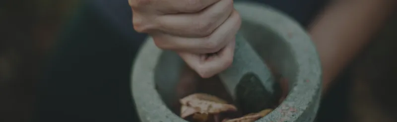 Mörser mit Hand macht Blätter klein
